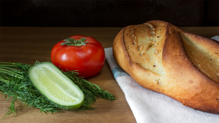 Potato bread, tomato and cucumber on wooden table.の写真素材