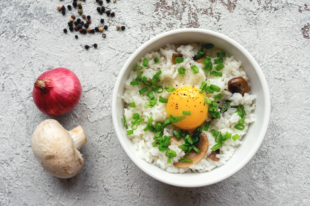 Hot white rice with raw yolk, mushroom and green onion. Top view. Japanese breakfast - Tamago Kake Gohan.の写真素材