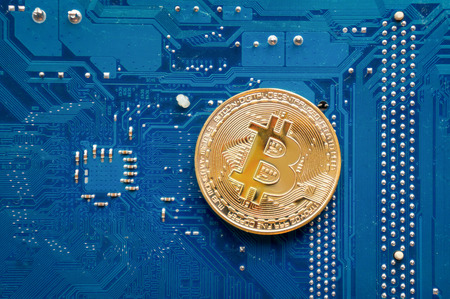 Gold bitcoin on motherboard. Top view. Crypto currency concept.の写真素材