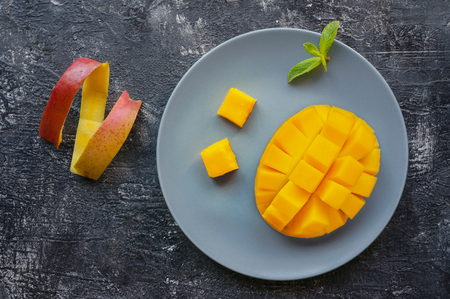 Sliced ripe mango fruit with peel on dark background. Top view.の写真素材
