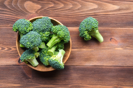 Fresh broccoli on kithen board. Top view. Wooden background with copy space.の写真素材