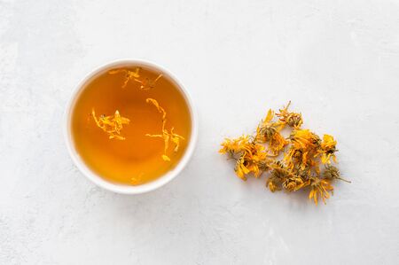Natural calendula (marigold) herbal tea on table. Top view.の写真素材