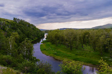 Cloudy summer day. One of the sleeves of the Yenisei River flowing along the low hills. Khakassia. Summer 2014. June.の写真素材