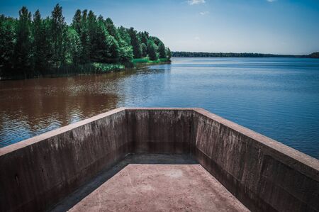 Part of the dam overlaps the river. Landscape of river, forest and blue sky.の写真素材