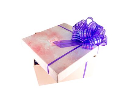 Pink box with a big bow isolated on white backghround. Closeup photo of Christmas or birthday presentの写真素材