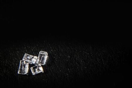 White sugar crystals on a black background in macro. Food photo with copy space  can be used like postcardの写真素材
