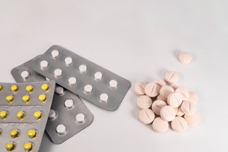 White medical pills and tablets on white background. Closeup photo of medical preparations with copy spaceの写真素材