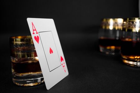 Short Glass of dark red whiskey, brandy or 
bourbon isolated on black background. Closeup photo of alcoholの写真素材