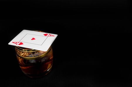 Glass of dark red whiskey, brandy or 
bourbon isolated on black background. Closeup photo of alcoholの写真素材