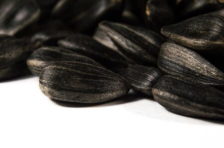 Black sunflower seeds in  macro isolated on white background. Food photo with texture closeup.の写真素材