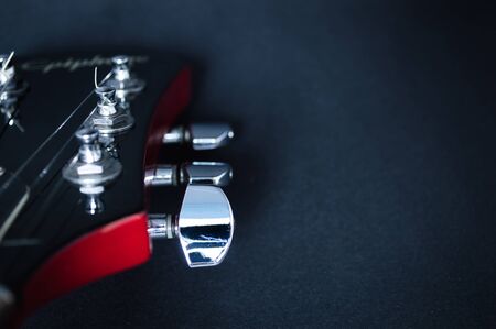 Red electric guitar with neck strings, fingerboards closeup isolated on black backgroundの写真素材