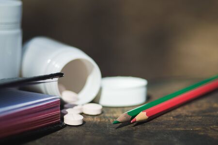 White  pills lie on an old bench. Pills or tablets closeup with bokeh.の写真素材