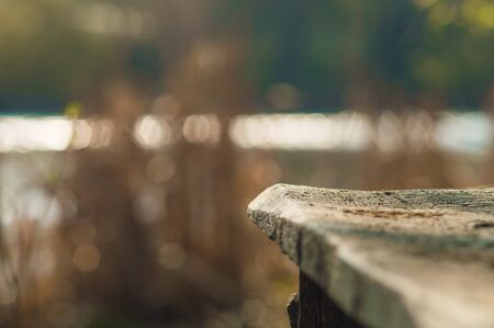 Wooden board on background from blurred river. Closeup photo with bokeh.の写真素材