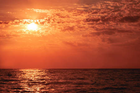 Warm summer sunset over sea in red colors. Sunset sea landscapeの写真素材