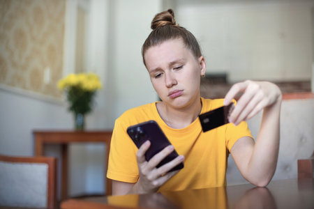 Internet fraud. Nervous sad upset unhappy confused young woman, stressed worried lady having problem with paying, buying online, shopping, stolen money, payments with credit blocked bank cardの写真素材