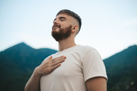 happy handsome man relax nature, young calm carefree man traveler with open raised hands enjoy mountain, one person feeling good, breath deep deeply fresh air. Freedom, travel, happiness conceptの写真素材
