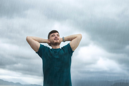 happy handsome free guy, young calm relaxed carefree man traveler with open raised hands enjoy sea, ocean view, person feeling good, breath deep deeply fresh air. Freedom, travel, happiness conceptの写真素材