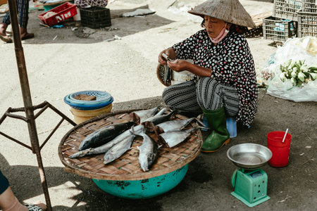Nah Trang, Vietnam - December 26, 2022: Vietnamese woman selling food, fish on a street in the old town of Nha Trang, Vietnam, Asiaのeditorial素材