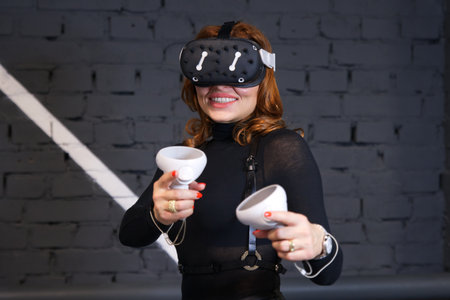Sexy hot happy young beautiful woman, young girl using, wearing a modern device virtual reality headset mask, helmet or 3D, AR, VR glasses, playing the game. People and technology metaverse conceptの写真素材