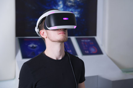 Portrait of happy young handsome man, guy using, wearing a modern device virtual reality headset mask or 3D, AR, VR glasses, playing the game. People and technology metaverse conceptの写真素材