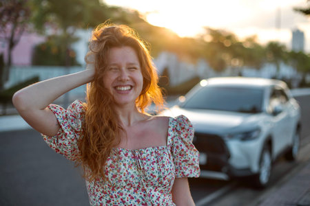 happy girl driver next to her new car on the roadの写真素材