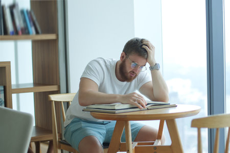Portrait of serious concentrated guy, young man in glasses college or university student is study...