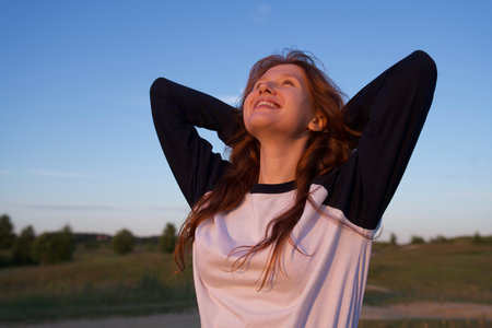 Portrait of young woman, teenager girl having fun outdoors at countryside looking at camera and smileの写真素材