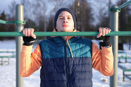 Young fit man is training workout outdoors at winter cold snowy day. Healthy fitness lifestyle...