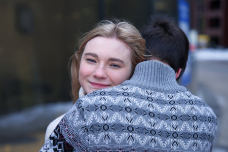 Young couple hug each other, young woman, teenager girl is looking at cameraの写真素材