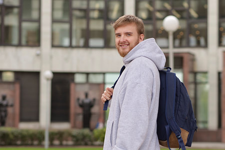 Portrait of young man university or college student at campus outdoors with backpackの写真素材
