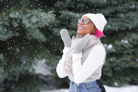 Happy young woman play with snow at winter cold dayの写真素材
