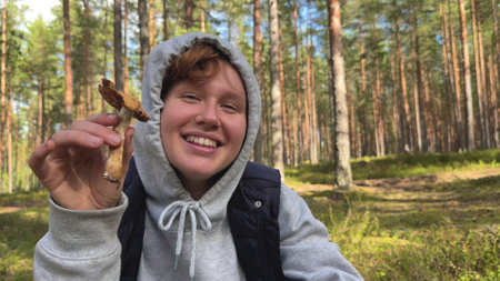 happy young woman in the forest with a mushroom, forester, autumnの写真素材