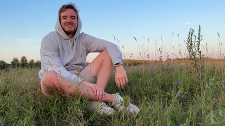 young cute woman dreaming and praying outdoors at sunset or sunrise in the parkの写真素材