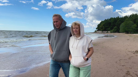 Portrait of happy elderly senior couple in love walking on a beach at summer, smile, laugh, have funの写真素材