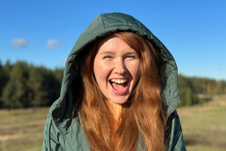 Portrait of happy young woman smile while walking in golden autumn park or forest at sunny day,...