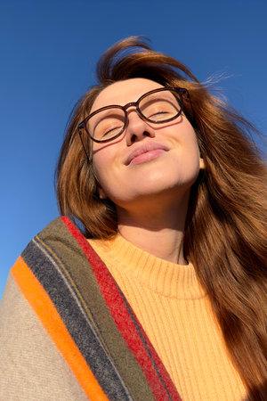 Portrait of happy young woman smile while walking in golden autumn park or forest at sunny day,...