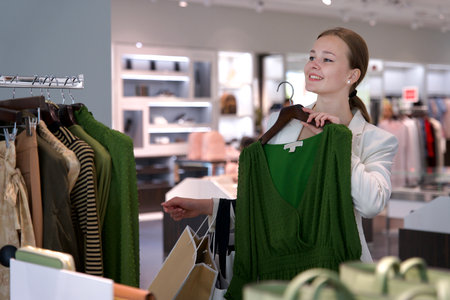 Young happy beautiful woman, elegant girl is shopping in the outdoors mall holding bags in handの写真素材