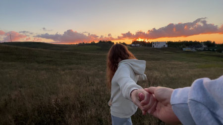 young cute woman dreaming and praying outdoors at sunset or sunrise in the parkの写真素材