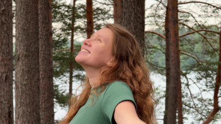 Young woman enjoy nature, breath deep fresh air at pine forest at summer day