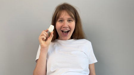 beautiful pregnant woman holding piece of chalk, biting. concept eat chalk, health, calcium