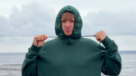 Depressed sad upset man frozen on a cold beach, bad vacation