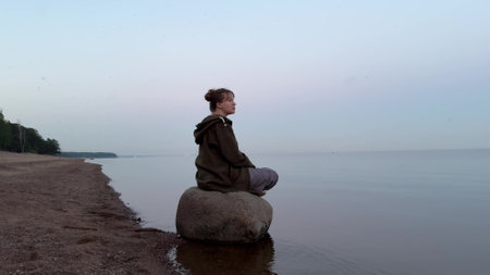 Young pensive depressed woman sitting on the beachの写真素材