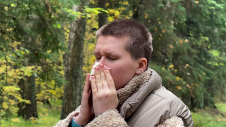 woman blowing her nose with a handkerchief. concept disease, runny nose, runny nose, autumn, cold