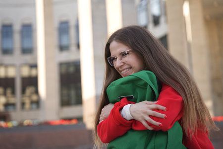 A joyful embrace shared between friends in a lively urban setting filled with vibrant energyの写真素材