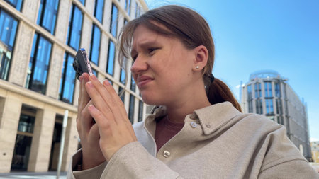 beautiful young woman using phone on street. concept communication, addiction, chatting, myopia,...