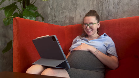 pregnant happy young woman working on tablet. concept businesswoman, online call, trainingの写真素材
