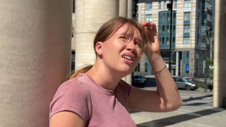 Young woman is suffering because of heat, hot weather, having sunstrokeの写真素材