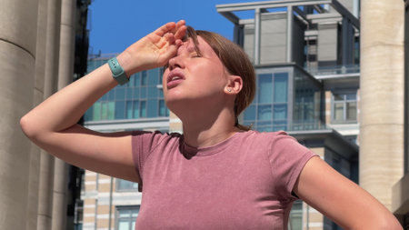 Young woman is suffering because of heat, hot weather, having sunstrokeの写真素材