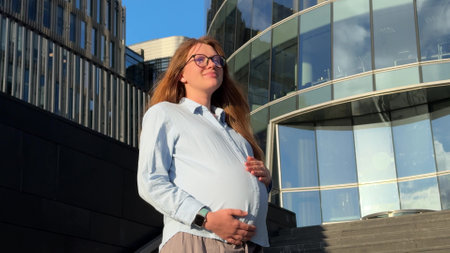 pregnant woman standing near business center in shirt. concept pregnancy, maternity leaveの写真素材