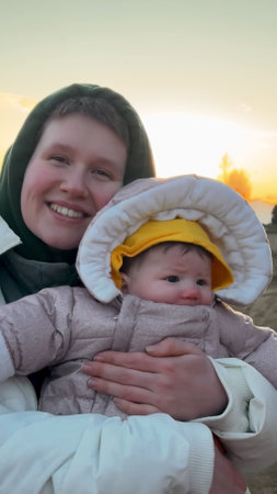 Happy mother with her daughter at sunsetの写真素材
